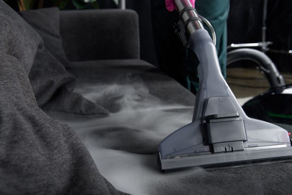 close-up-view-of-person-cleaning-sofa-with-vacuum-2024-11-18-08-59-38-utc